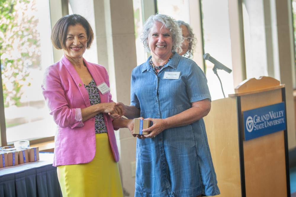 Provost Mili handing a retiree her gift.